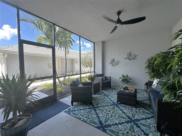 a living room with furniture floor to ceiling window and a potted plant