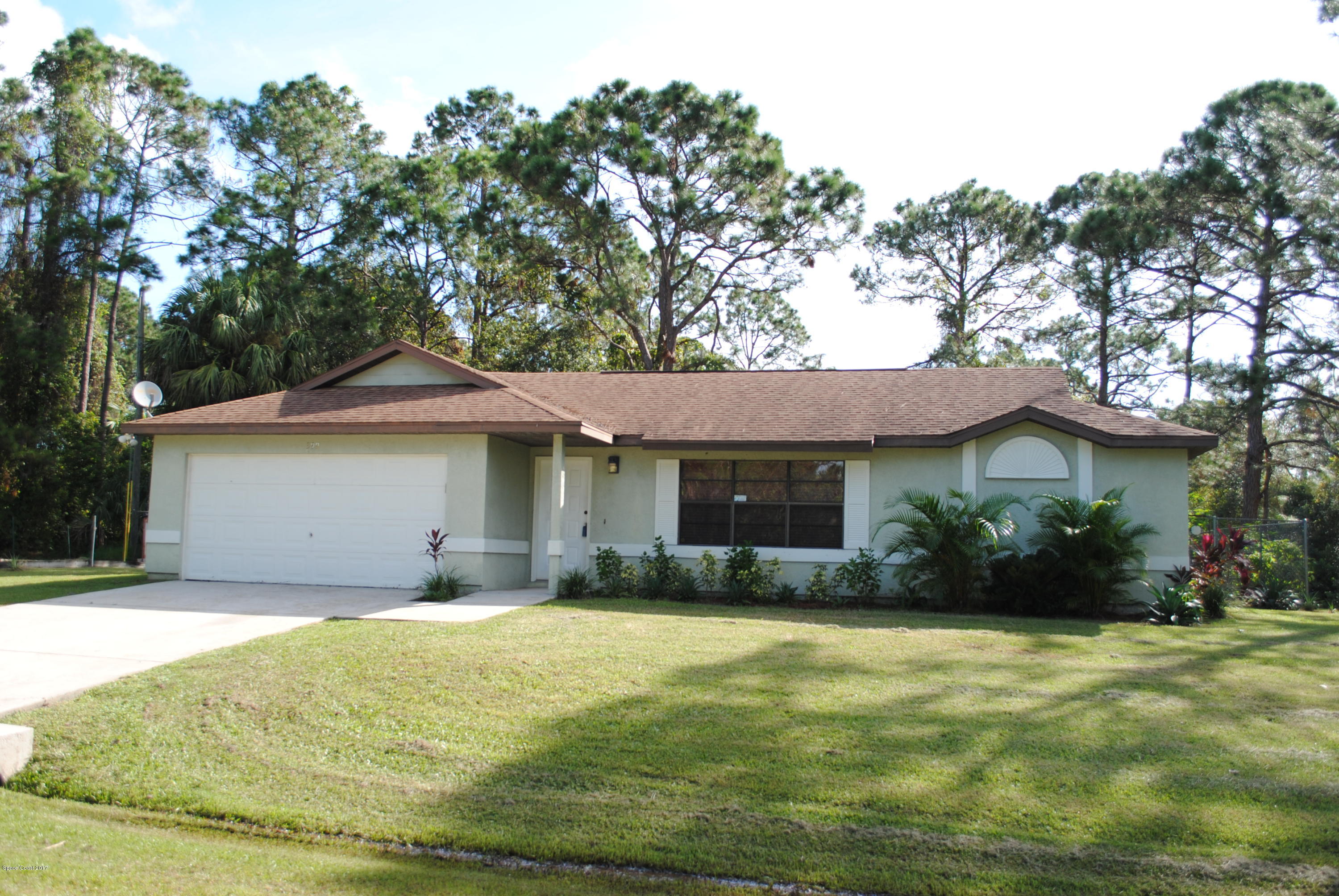 399 Warner Road Southwest Palm Bay, FL 32908 - Photo 1 of 40 a front view of a house with garden