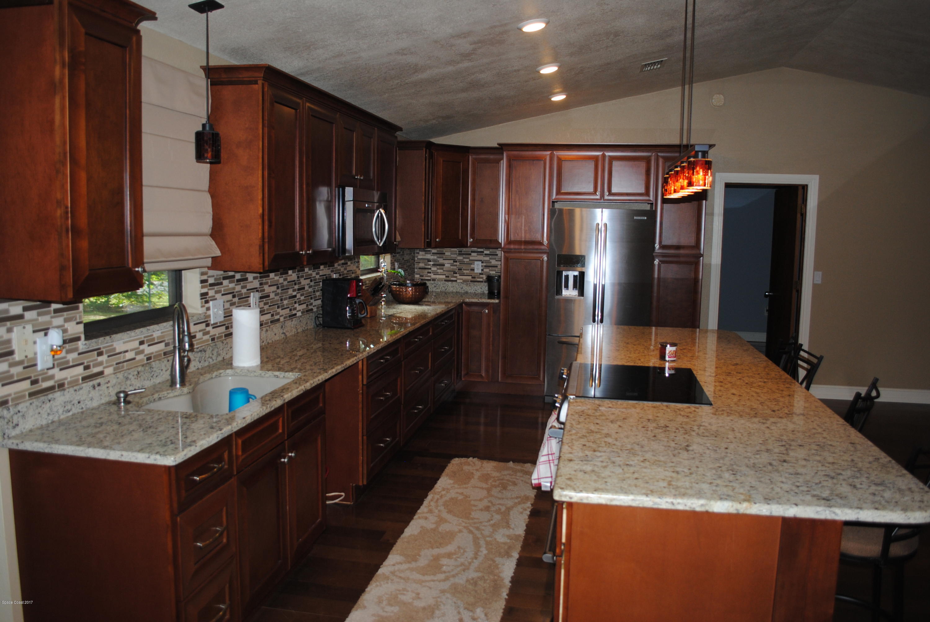 399 Warner Road Southwest Palm Bay, FL 32908 - Photo 5 of 40 a kitchen with stainless steel appliances granite countertop a sink refrigerator and cabinets