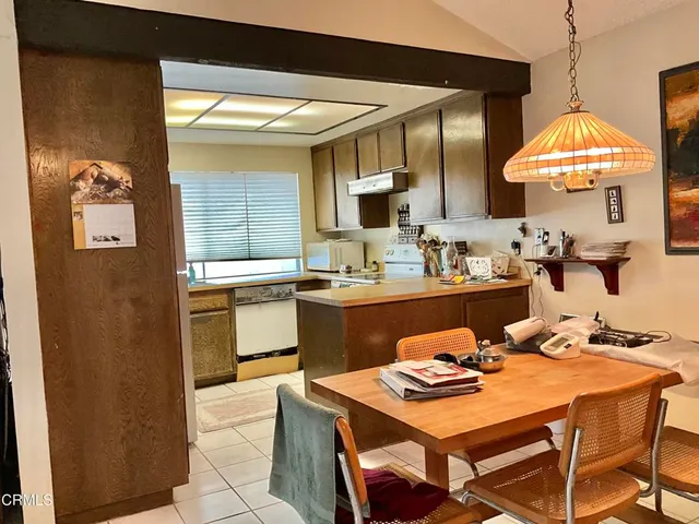 a kitchen with a sink a stove and chairs