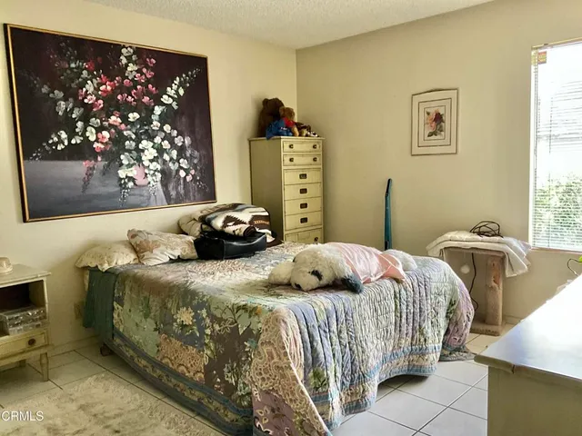 a bedroom with a bed and a flat tv screen on dresser