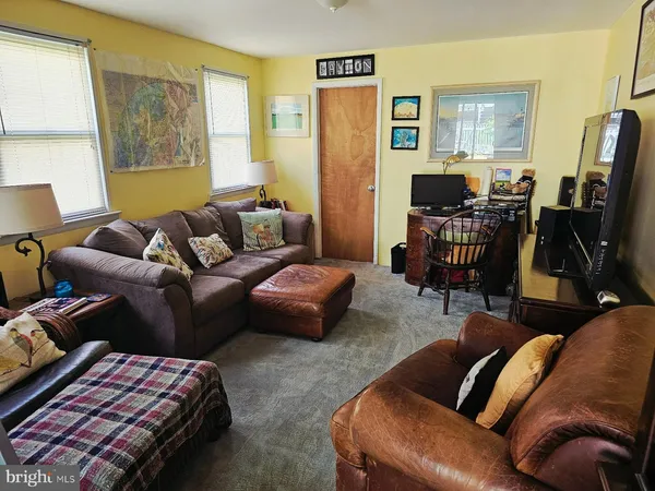a living room with furniture a flat screen tv and a window