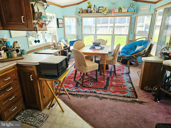 a view of a dining room with furniture a rug and wooden floor