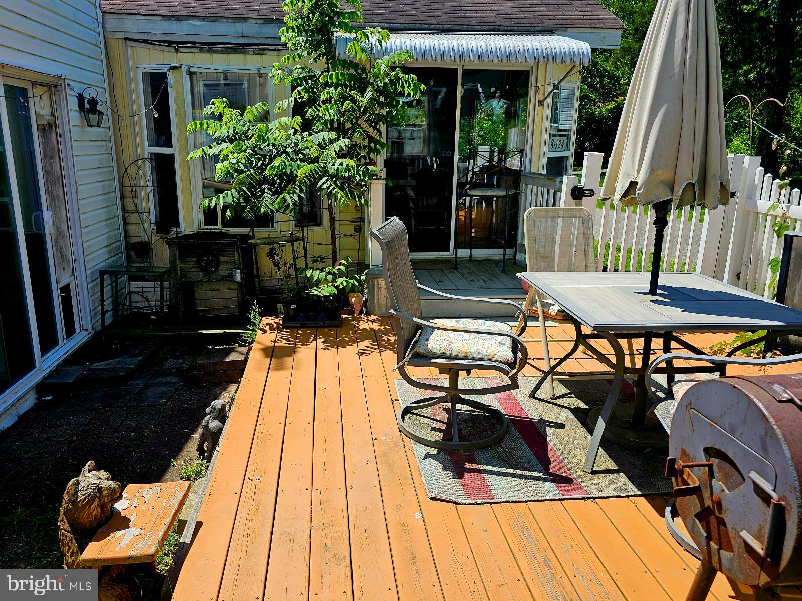 123-124 Palute Circle, Unit GLEN 8 Earleville, MD 21919 - Photo 35 of 40 a view of a patio with table and chairs potted plants with wooden floor and fence