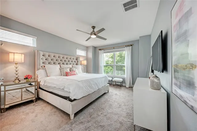 a bedroom with a bed flat screen tv and a large window