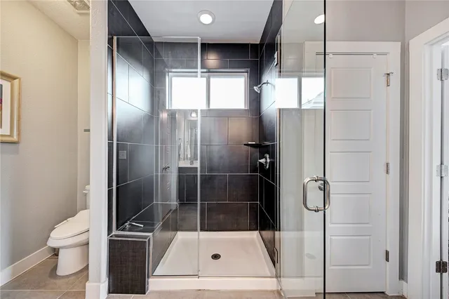 a bathroom with a toilet and a shower