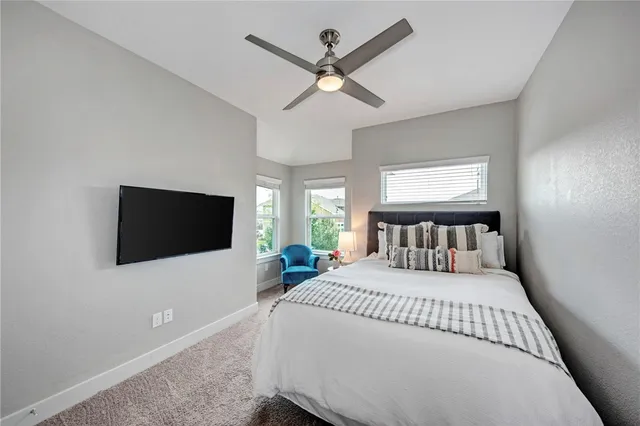 a bedroom with a bed a flat screen tv and a large window