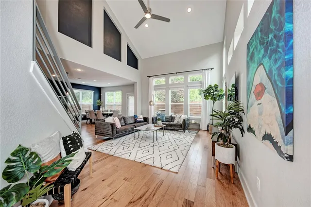 a living room with furniture large window and potted plants
