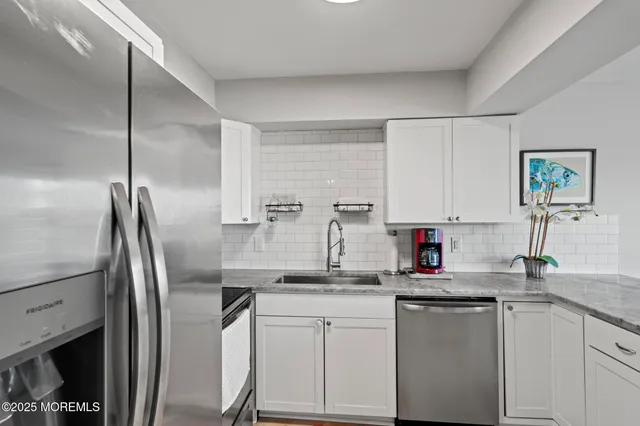 a kitchen with stainless steel appliances granite countertop a sink refrigerator and microwave