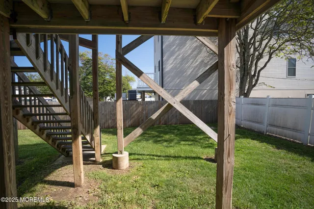 a backyard of a house with wooden stairs and table