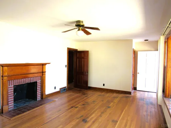 a view of a livingroom with wooden floor and a fireplace