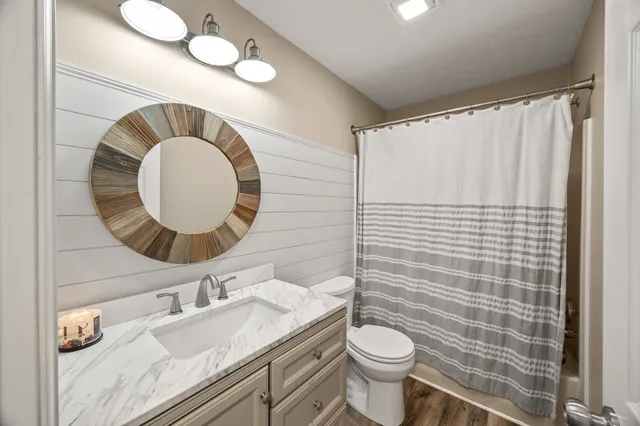a bathroom with a sink mirror vanity and toilet