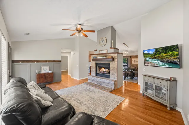 a living room with furniture a flat screen tv and a fireplace