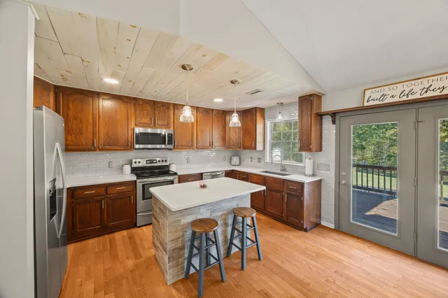 a kitchen with wooden cabinets a sink a stove a refrigerator and island