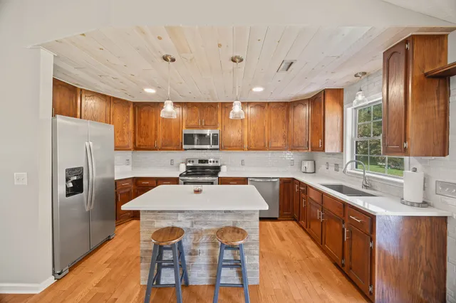 a kitchen with stainless steel appliances sink stove refrigerator and cabinets