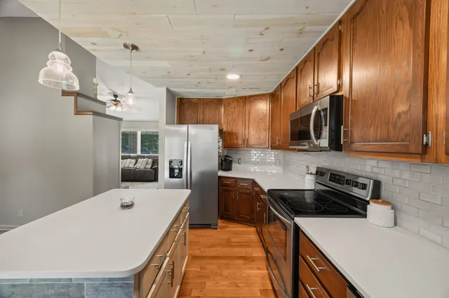 a kitchen with stainless steel appliances a stove sink microwave and refrigerator