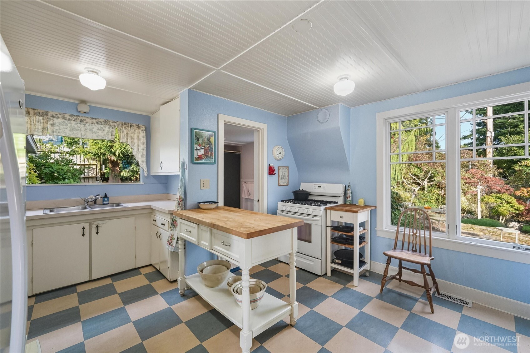 1131 16th Street Bellingham, WA 98225 - Photo 8 of 40 a kitchen with a stove a sink a dining table and chair with wooden floor