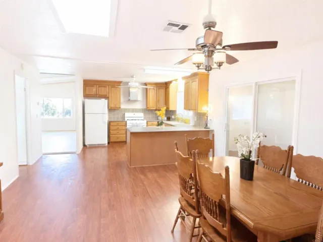a dining room with furniture a chandelier and wooden floor