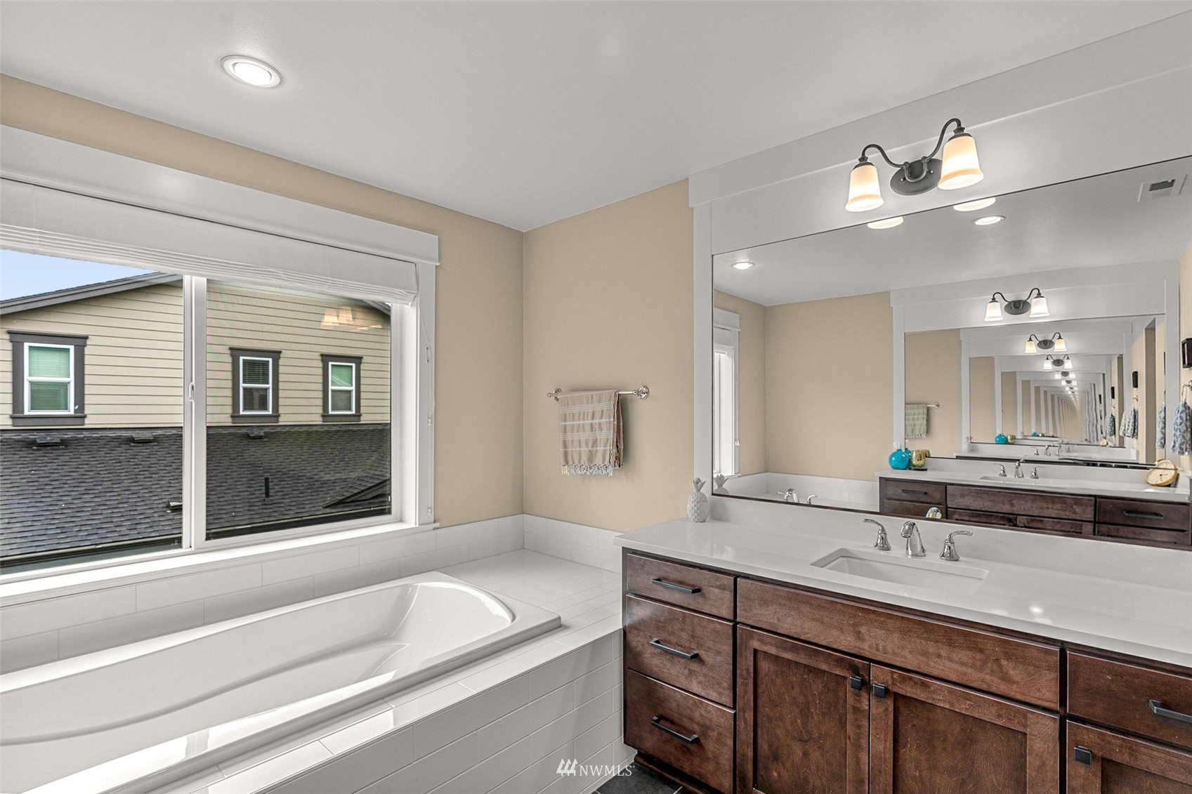 14408 160th Court Southeast Renton, WA 98059 - Photo 29 of 40 a bathroom with a granite countertop sink a large mirror and a bathtub
