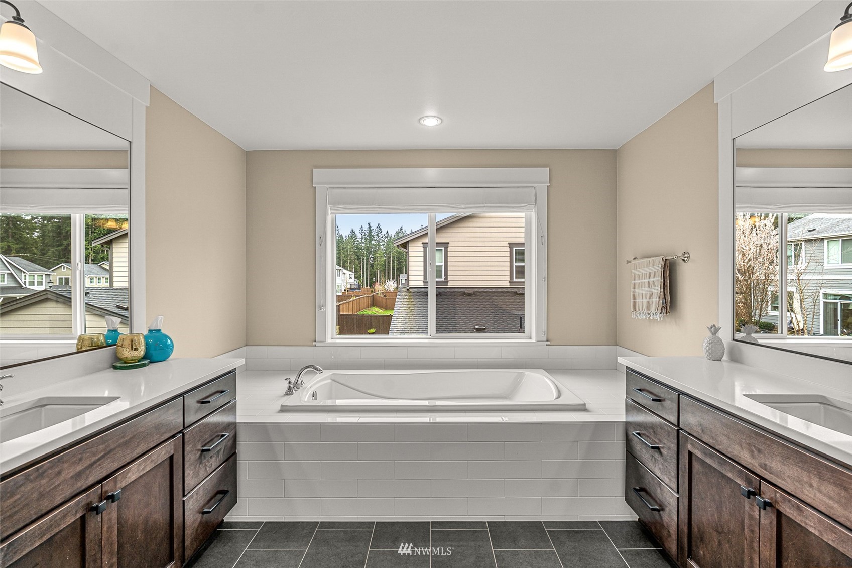 14408 160th Court Southeast Renton, WA 98059 - Photo 31 of 40 a bathroom with a granite countertop sink mirror bathtub and next to a window