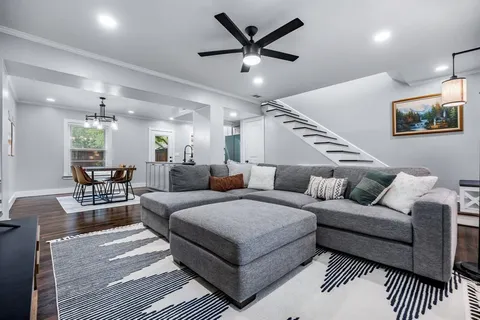 a living room with furniture and a wooden floor