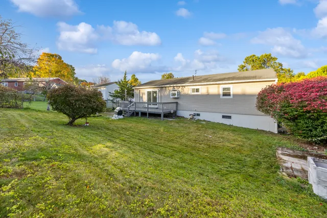 a view of a house with a big yard and a large tree center