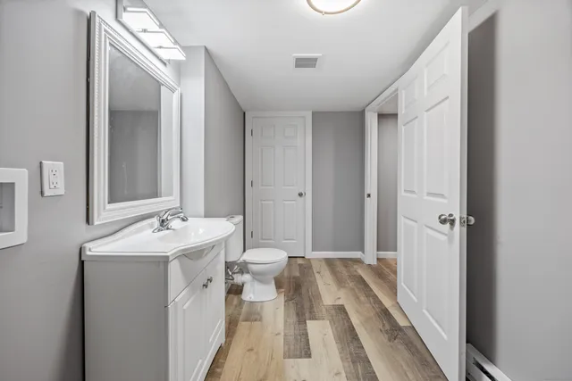 a bathroom with a sink and mirror with toilet