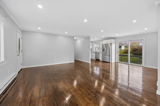 a view of empty room with wooden floor and windows