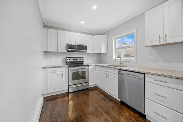 a kitchen with granite countertop white cabinets and white appliances