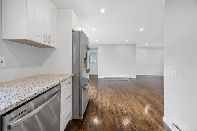 a kitchen with granite countertop a stove and a refrigerator