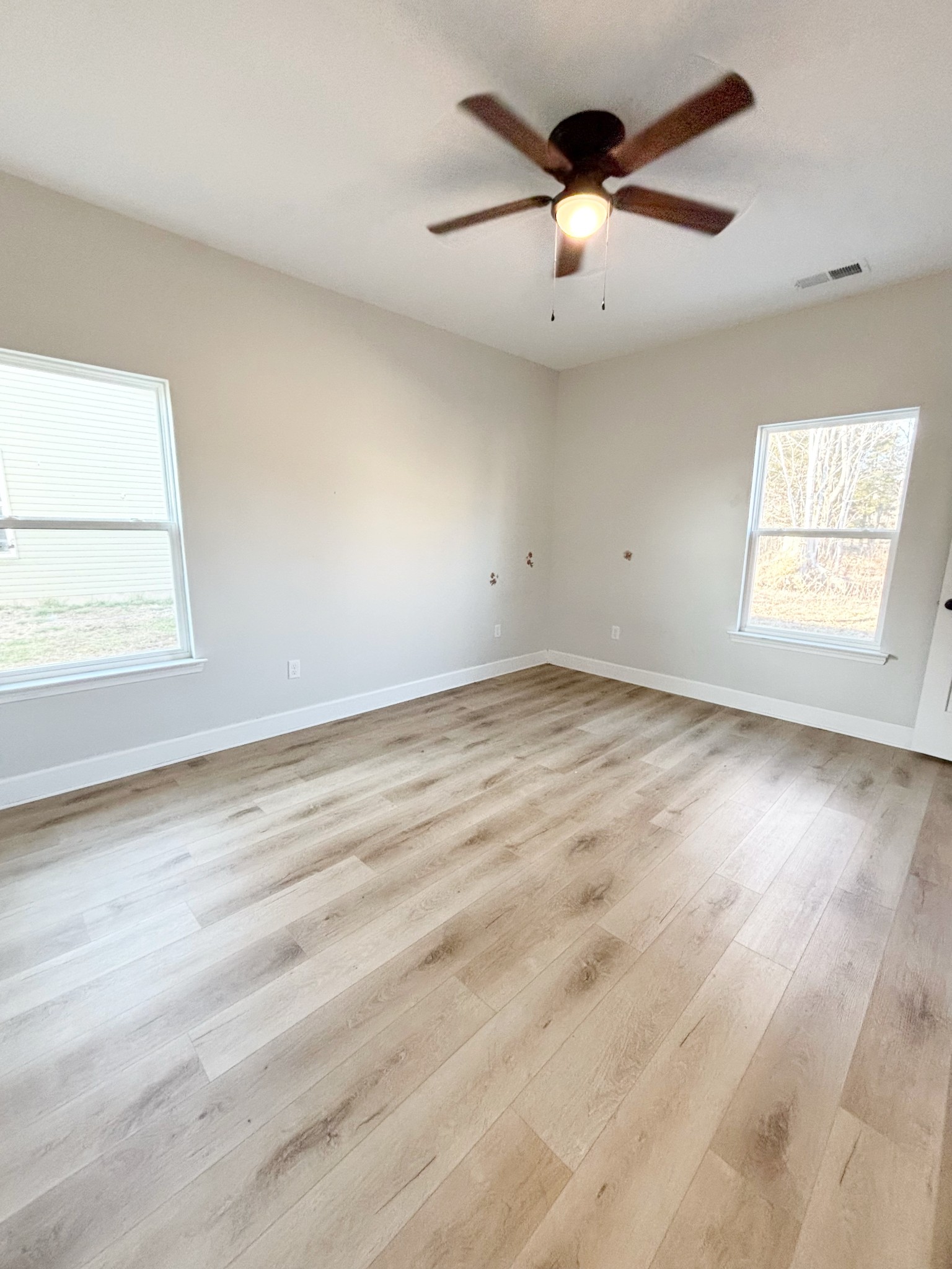 140 Eno Road Dickson, TN 37055 - Photo 7 of 11 an empty room with wooden floor ceiling fan and windows