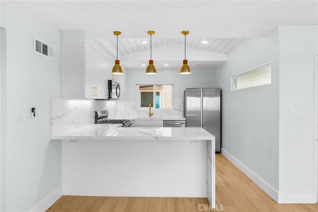 34381 Dana Strand Road, Unit 2 Dana Point, CA 92629 - Photo 13 of 32 a kitchen with kitchen island a sink a counter top space and stainless steel appliances