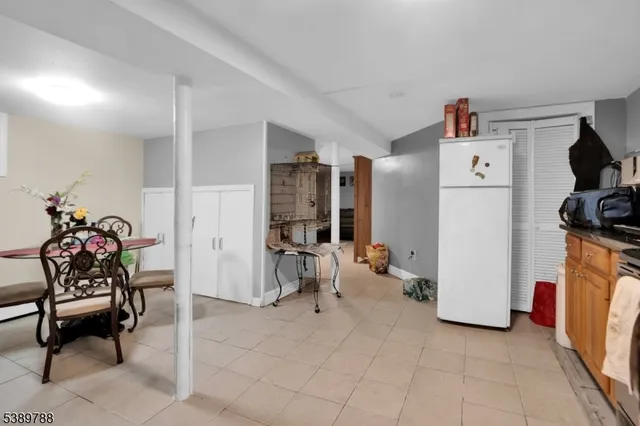 a living room with furniture a refrigerator and a chair