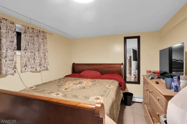 a bedroom with a bed and flat tv screen on the dresser