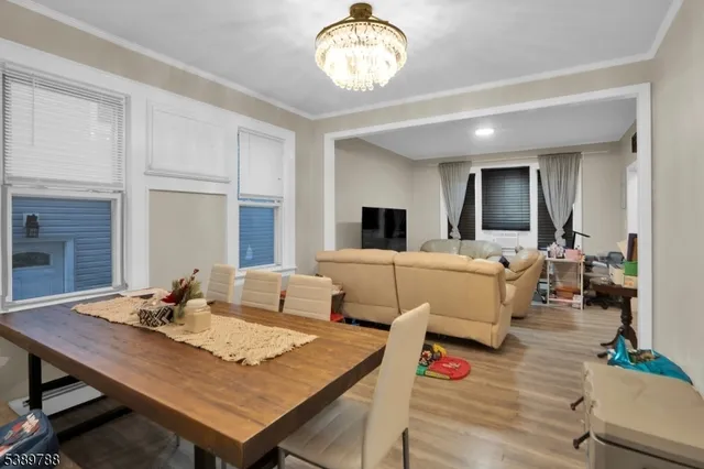 a living room with furniture kitchen view and a wooden floor