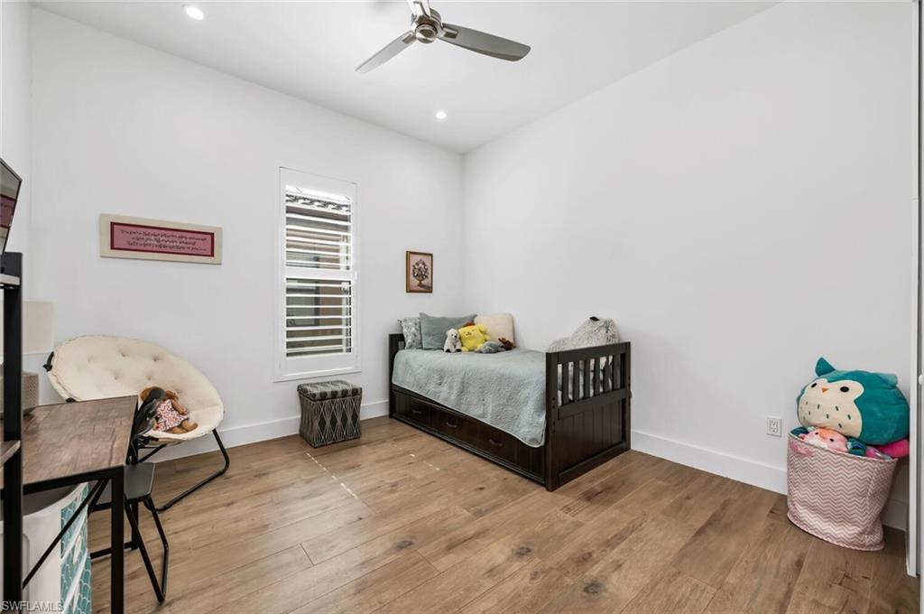 7437 Acorn Way Naples, FL 34119 - Photo 11 of 19 a bedroom with furniture and a wooden floor