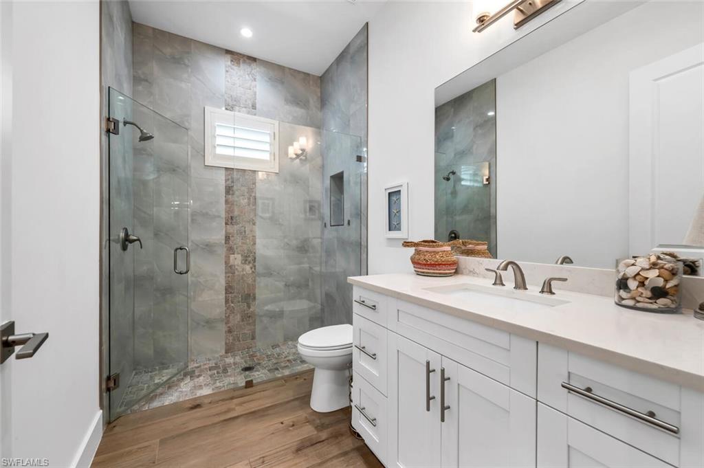 7437 Acorn Way Naples, FL 34119 - Photo 12 of 19 a bathroom with a double vanity sink toilet and shower