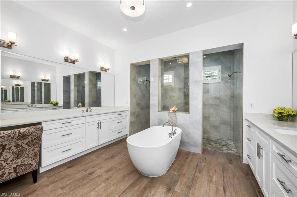 7437 Acorn Way Naples, FL 34119 - Photo 8 of 19 a bathroom with a tub sink and mirror