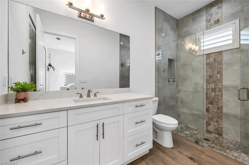 7437 Acorn Way Naples, FL 34119 - Photo 10 of 19 a bathroom with a double vanity sink toilet and shower