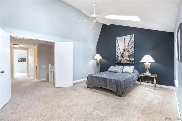 a spacious bedroom with a bed and a lamp