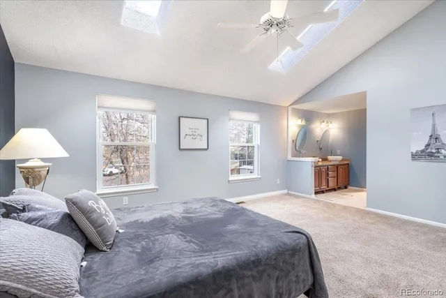 a spacious bedroom with a large bed and a chandelier