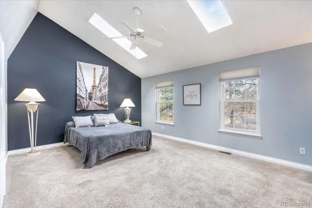 a spacious bedroom with a large bed and a chandelier