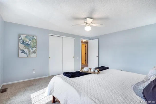 a bedroom with a bed and painting on the wall