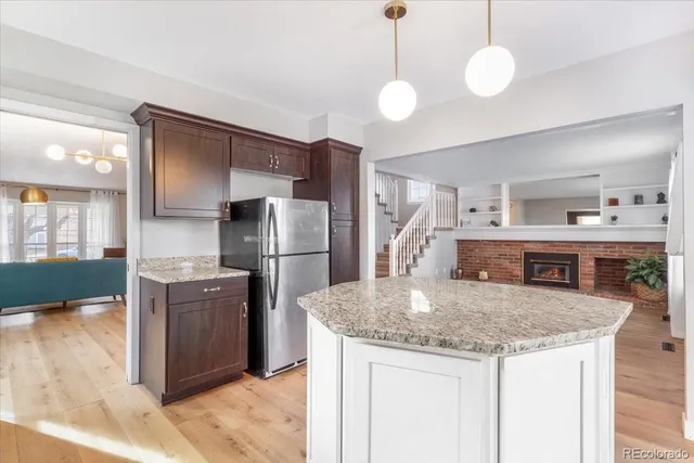 a kitchen with stainless steel appliances granite countertop a sink and a refrigerator