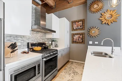 a kitchen with stainless steel appliances granite countertop a stove a sink and a microwave