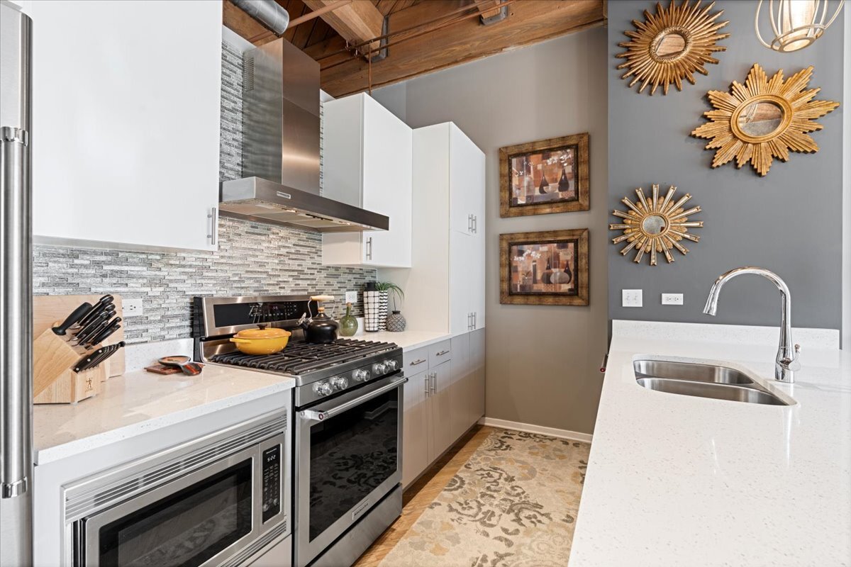 1040 West Adams Street, Unit 344 Chicago, IL 60607 - Photo 9 of 31 a kitchen with stainless steel appliances granite countertop a stove a sink and a microwave