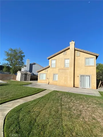 a view of an house with backyard and road