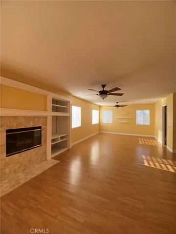 an empty room with windows and fireplace