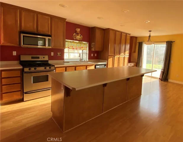 a kitchen with stainless steel appliances granite countertop a refrigerator a stove and a sink