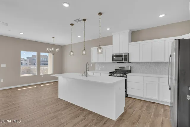 a view of kitchen with stainless steel appliances refrigerator stove microwave and cabinets